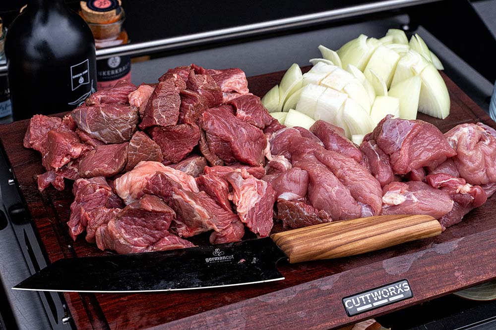 Das Fleisch sowie eine der beiden Gemüsezwiebeln grob in kleine Stücke schneiden.