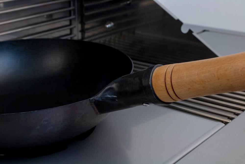 Der Holzgriff ist stabil am Wok befestigt Der Holzgriff ist stabil am Wok befestigt