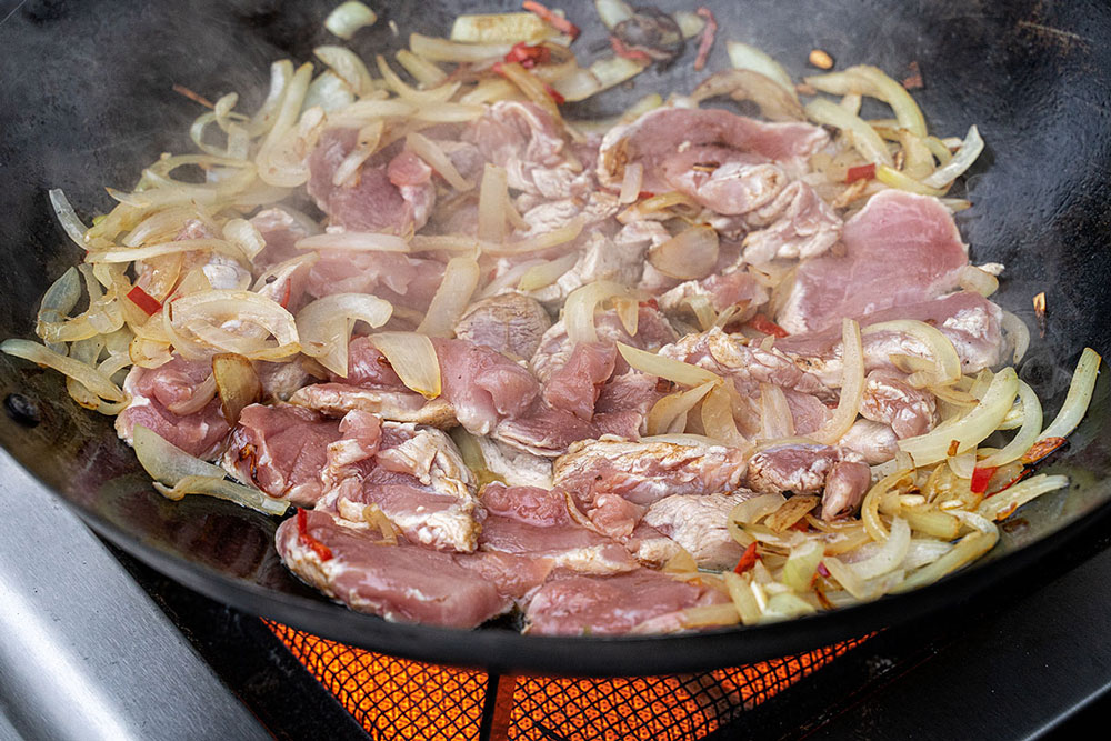 Das Schweinefilet hinzufügen und von allen Seiten scharf anbraten.
Danach aus dem Wok nehmen und warm halten.