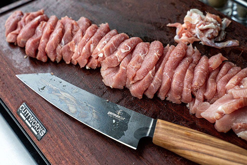 Das Schweinefilet mit einem scharfen Messer parieren und
in relativ dünne, mundgerechte Stückchen schneiden.
