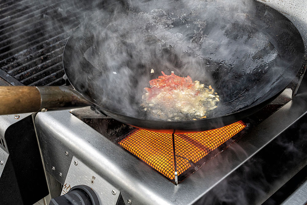 Zwiebeln in Streifen schneiden, Cocktailtomaten
halbieren, Chili und Knoblauch hacken.
Wok mit Sesamöl benetzen, Chili und Knoblauch andünsten,
dann Zwiebeln hinzufügen und weiterdünsten.