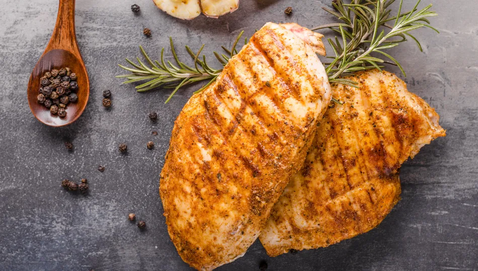 Knusprig braun gegrillte Hähnchenbrustfilets frisch vom Rost, glänzend glasiert mit einer würzigen Hähnchen-Marinade aus Kräutern und Zitrone.