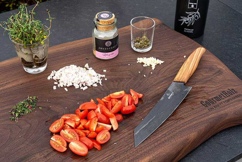 Den Knoblauch und die Schalotte klein würfeln, 1 EL Thymian klein hacken,
die Cocktailtomaten vierteln sowie die Kapern,
braunen Zucker und das Olivenöl bereitstellen.